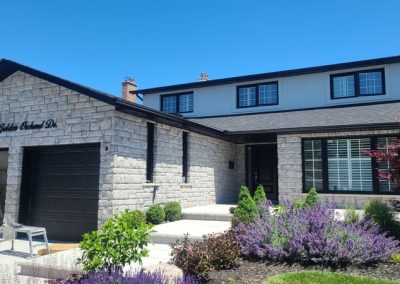 Painting your vinyl windows black can dramatically change the look of your house. Stone and stucco was added to complete the look